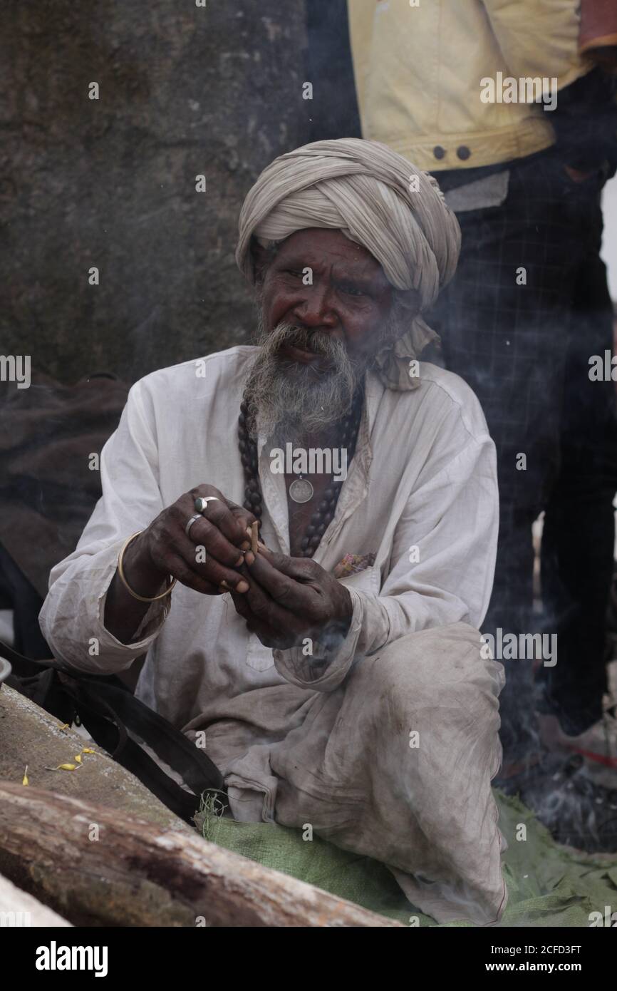 Sadhu prepares weed as an offering to Lord shiv on the auspicious occasion of Shiv ratri. Stock Photo