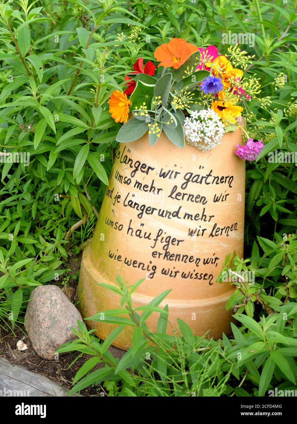Upside down terracotta pot with saying, as garden decoration Stock Photo