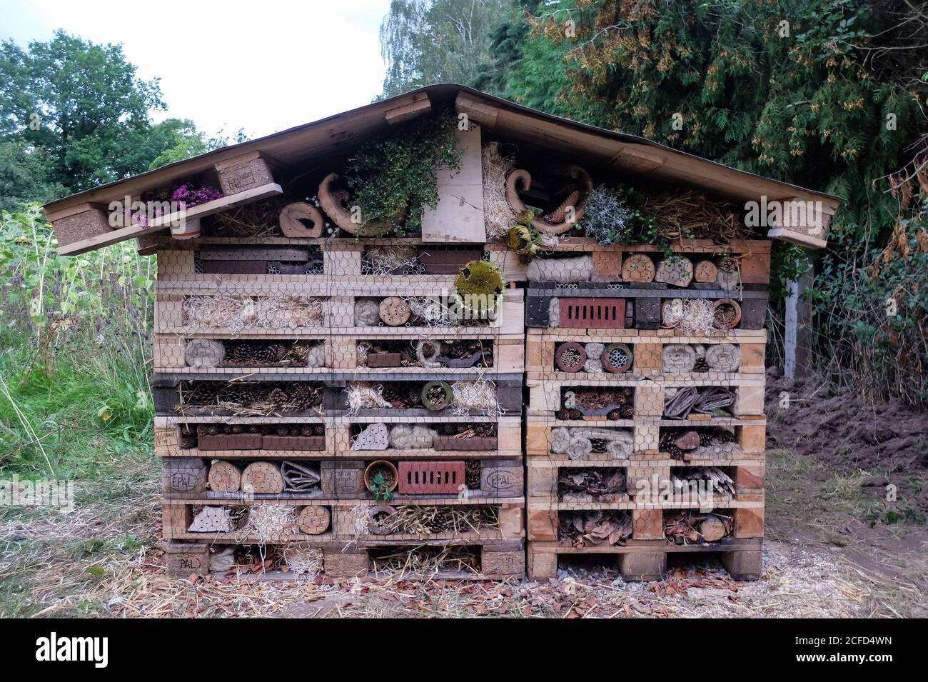 Large insect hotel made of pallets, perforated stones and many natural materials Stock Photo