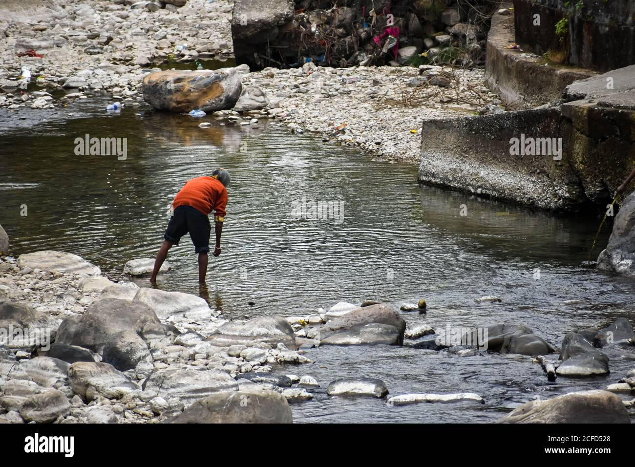A local man fishing in the river. Dehradun Uttarakhand India Stock Photo