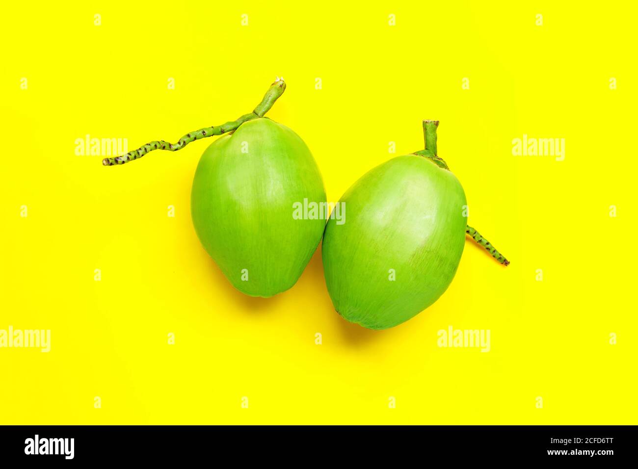 Fresh young coconuts on yellow background. Top view Stock Photo