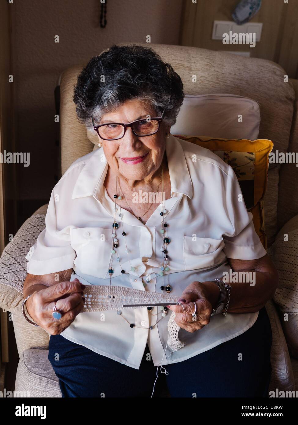 Elderly woman sitting in an armchair hi-res stock photography and ...