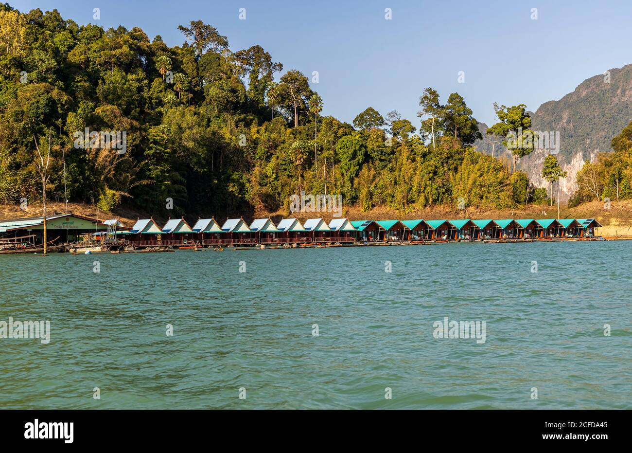 View over footbridge with bungalows (Khao Sok Smiley Lake House) on the water of Ratchaprapha Lake in Khao Sok National Park, Khao Sok, Thailand Stock Photo