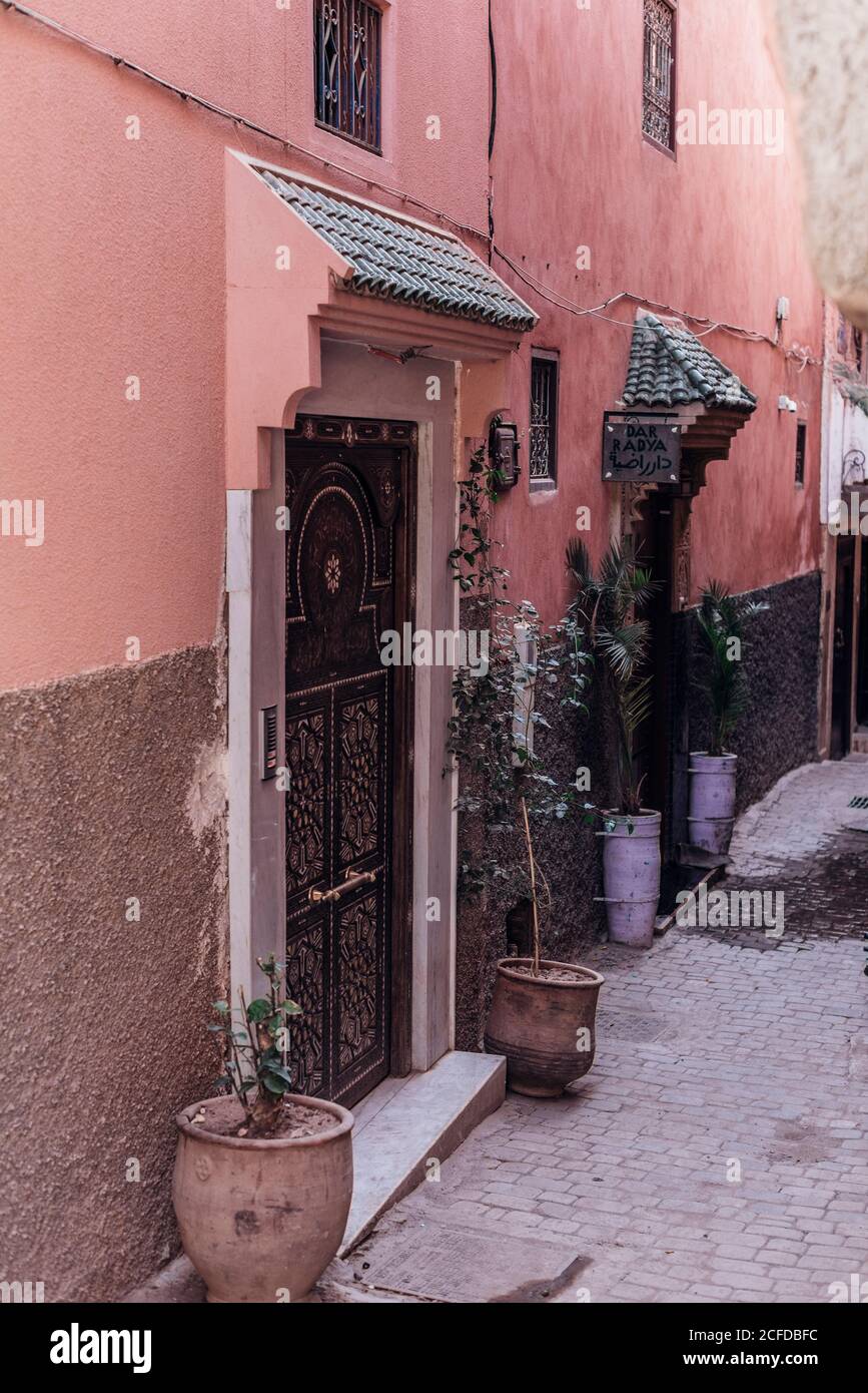 Pots with plants placed outside doors of shabby building on street of Marrakesh, Morocco Stock Photo