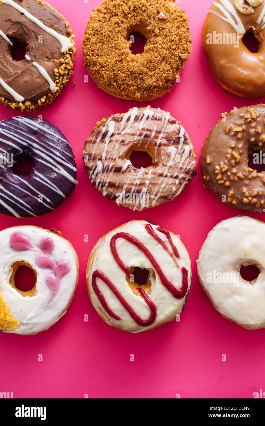 Variety of doughnuts on pink background Stock Photo