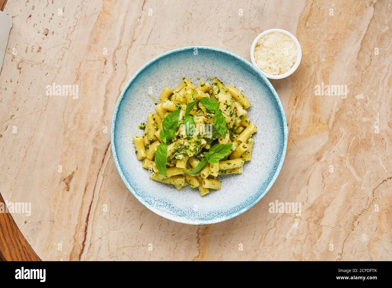 Top View Of Boiled Noodles Decorated With Green Herbs On Blue Plate Served With Small Bowl Of Grated Cheese Stock Photo Alamy