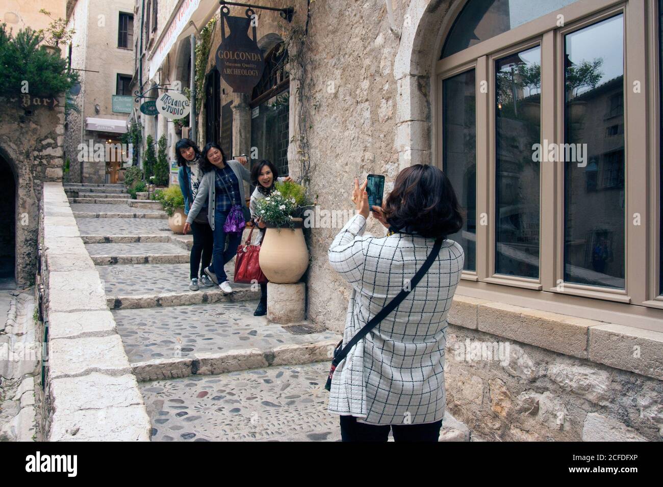 Saint-Paul-de-Vence France Group selfie. Snapshot of three graces. Japanese girl is taking a picture of her girlfriends in the old town. Stock Photo