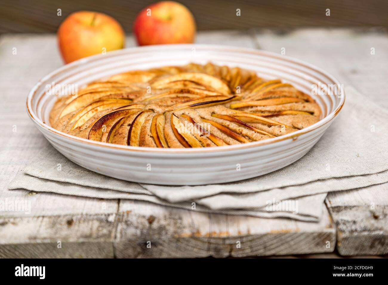 Apple pie baked in a round shape and decorated with apple slices, decorated with two apples Stock Photo