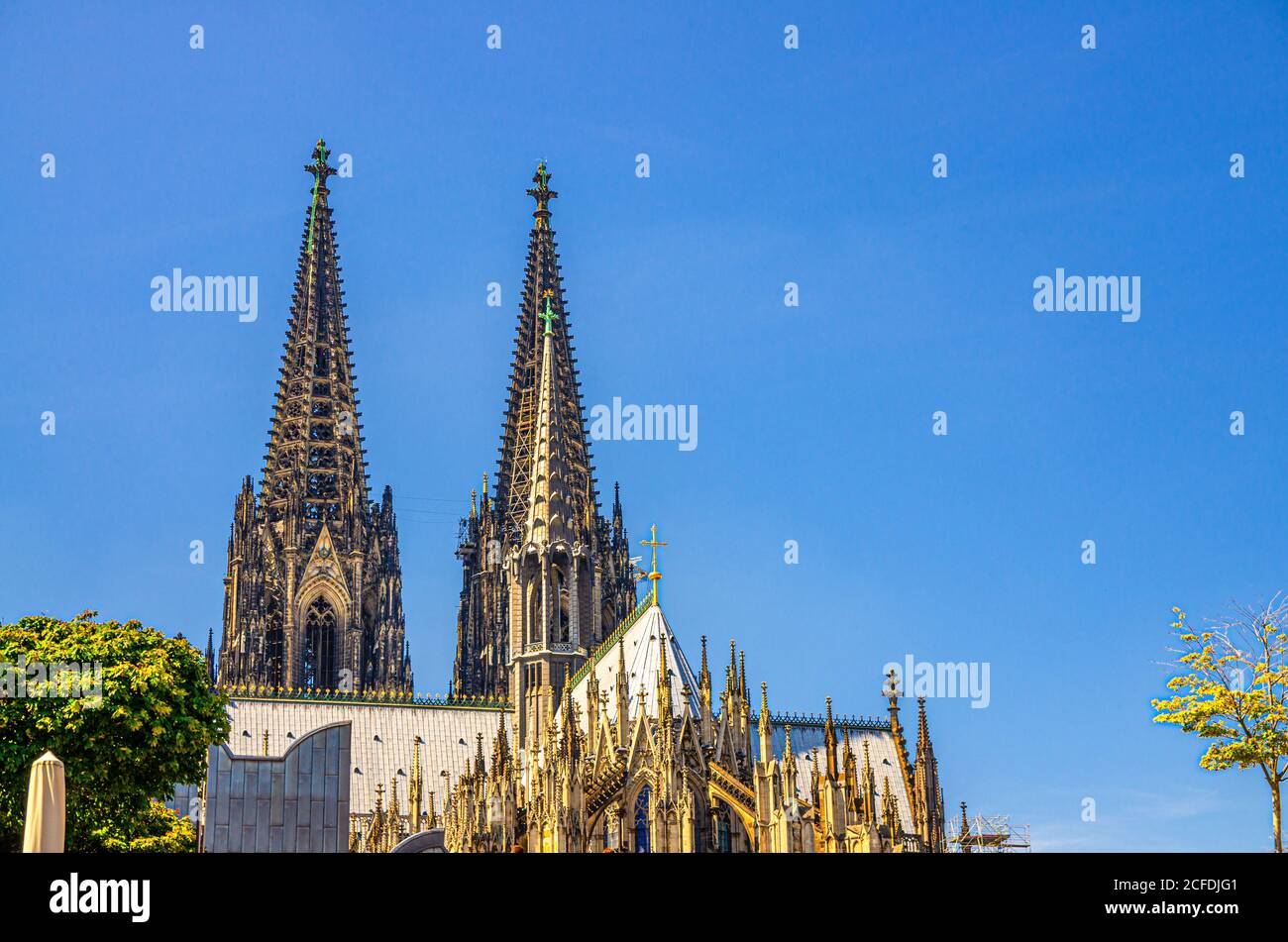 Two huge spires of Cologne Cathedral Roman Catholic Church Saint Peter gothic architectural style building in historical city centre, blue sky in sunny day copy space, North Rhine-Westphalia, Germany Stock Photo