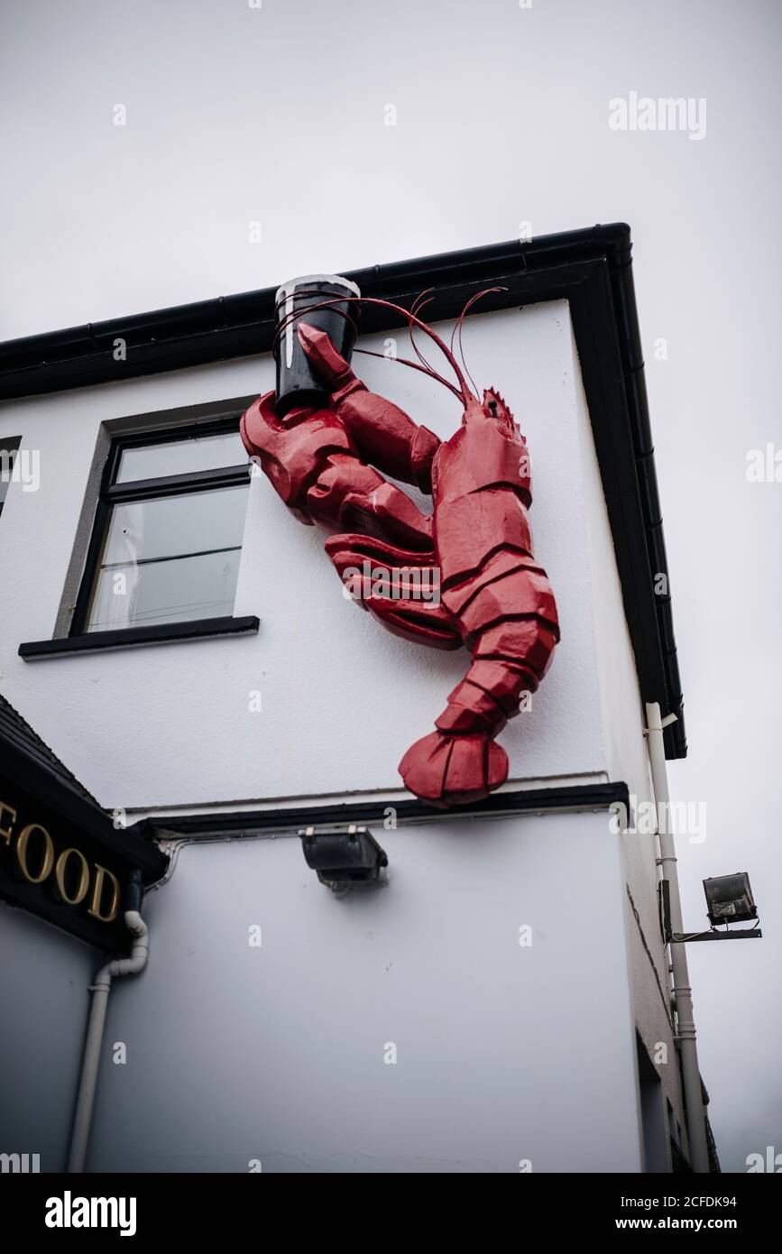 red lobster holding a pint, The Lobster Bar & Restaurant in Waterville, Ireland Stock Photo