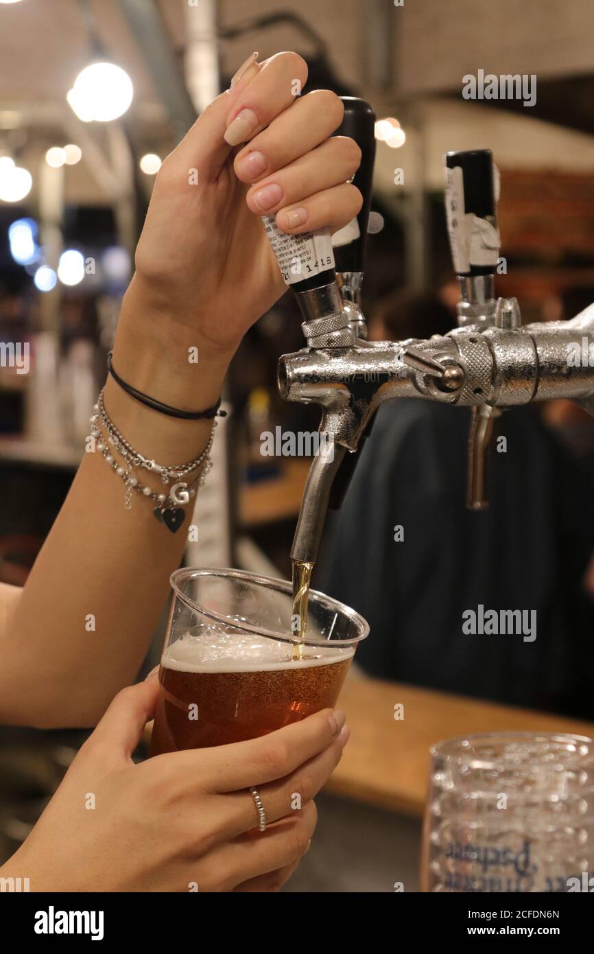Female hand tapping beer during an evening event Stock Photo Alamy