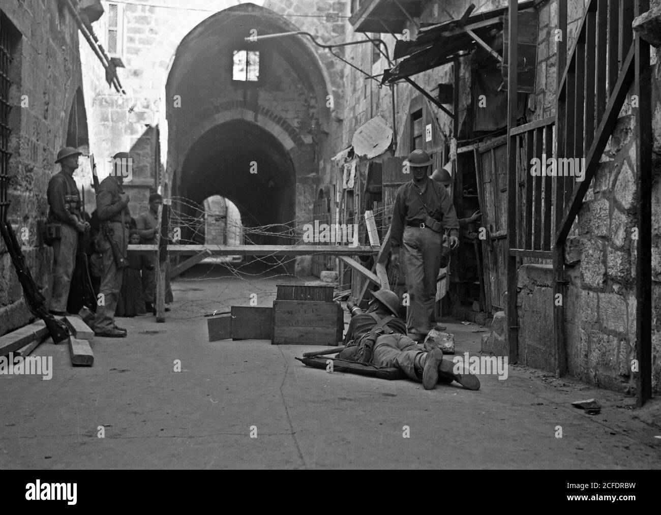 Original Caption:  The raising of the siege of Jerusalem. Typical scene of troops in Old City before the lifting of curfew. War-like scene in Bab el-Silseleh quarter with machine-gun in foreground entrance to Mosque grounds in distance  - Location: Jerusalem ca.  1938 Stock Photo