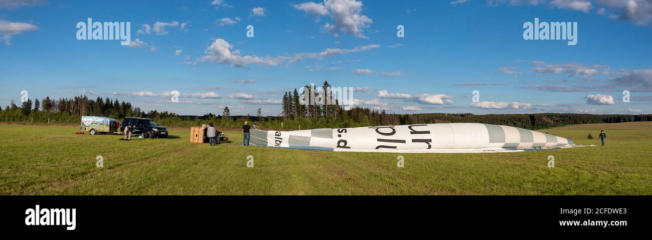 Germany, Saxony-Anhalt, fir, pilot and passengers are preparing to launch a hot air balloon. Stock Photo