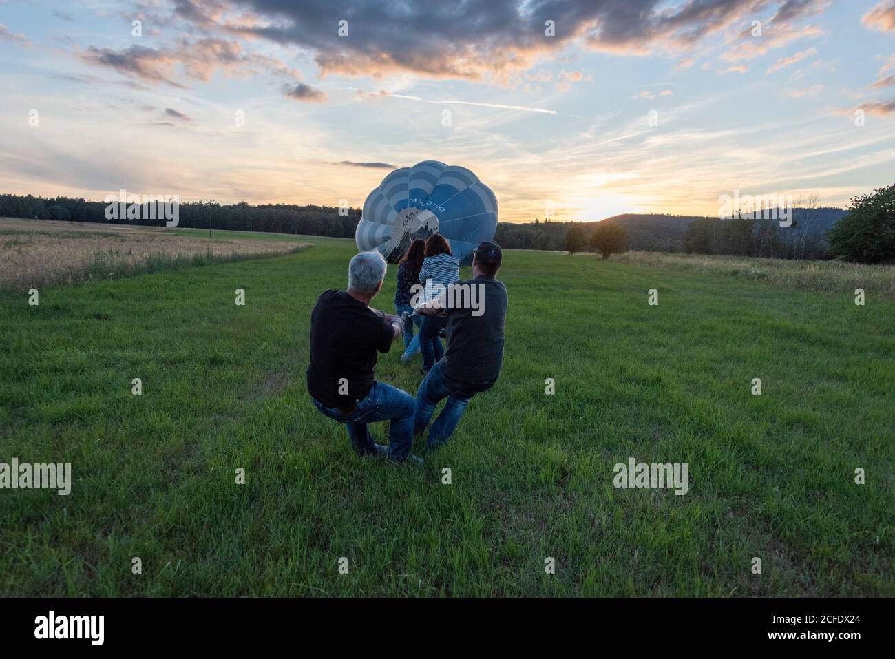 Germany, Thuringia, Ellrich, four people pull on a hot air balloon. Stock Photo