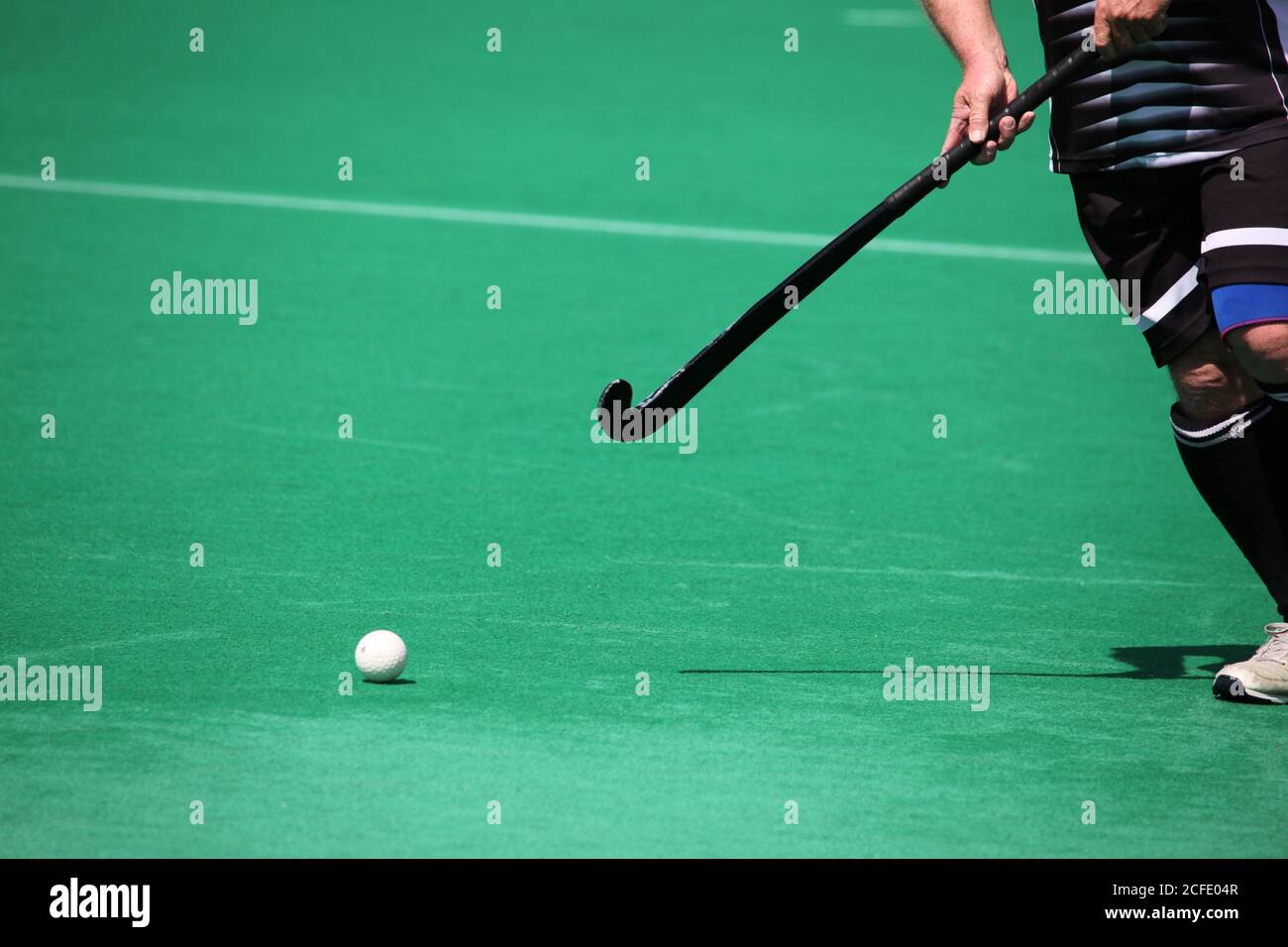 A field hockey player about to pass the ball Stock Photo