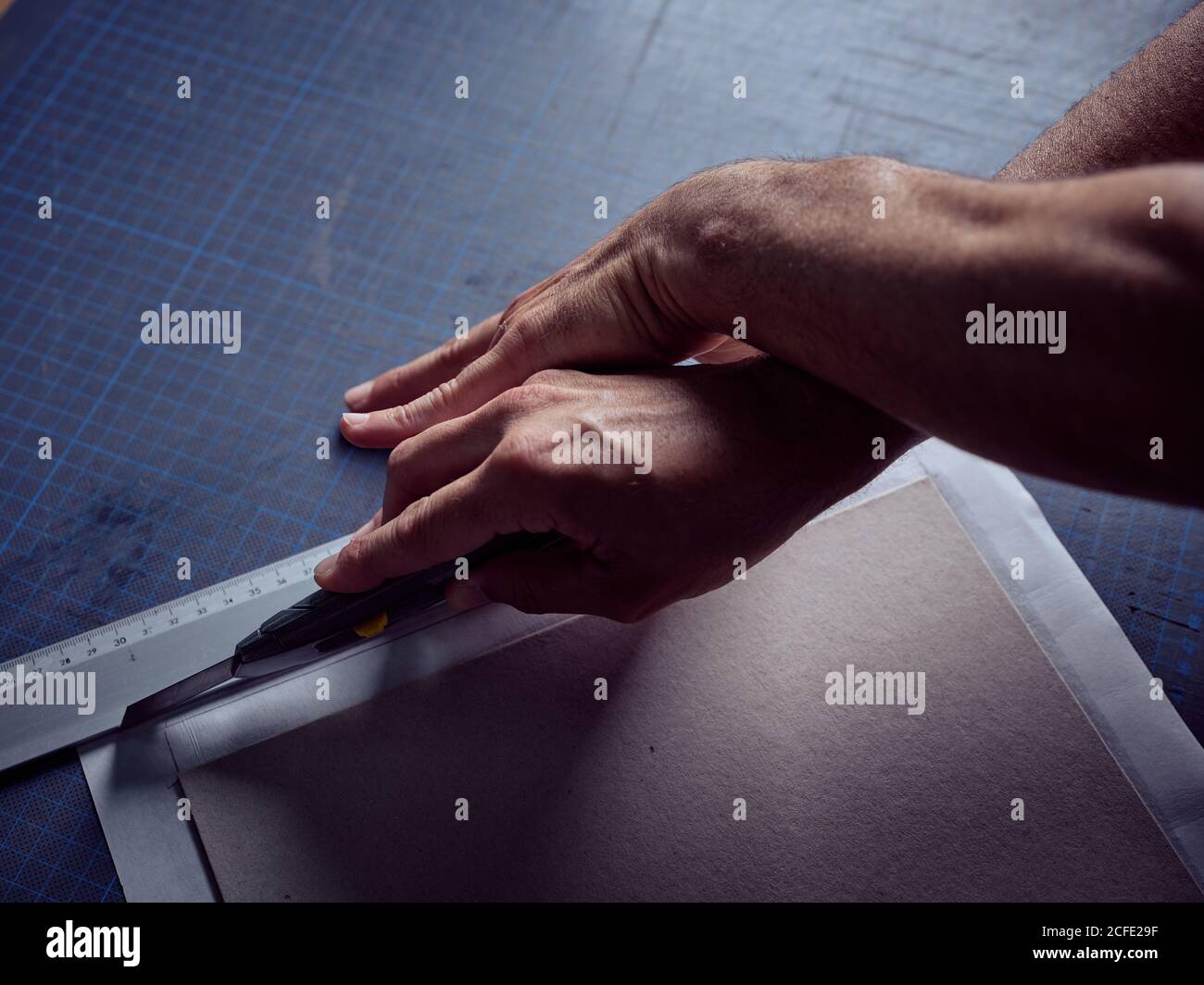 Craftsmanship cutting cardboard with paper knife Stock Photo Alamy