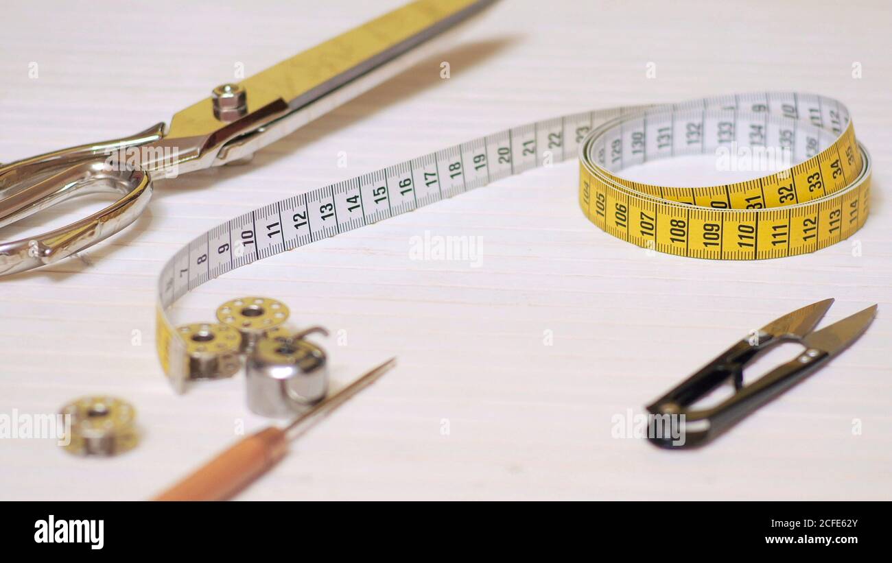 https://c8.alamy.com/comp/2CFE62Y/tailor-tools-isolated-on-wooden-background-scissors-needle-tailoring-meter-hand-2CFE62Y.jpg