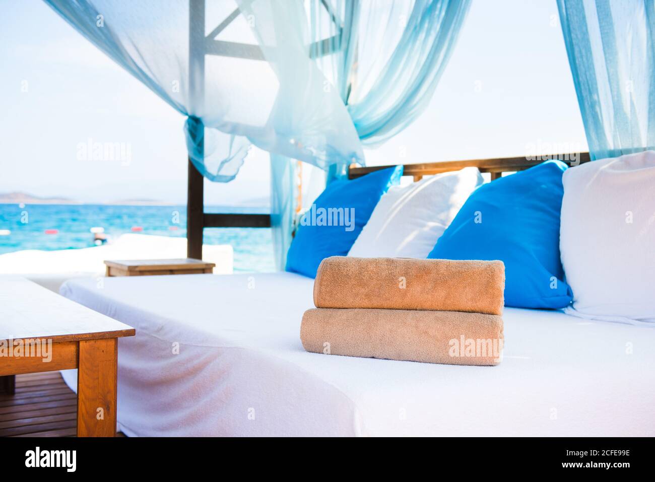 Set of rolled beach towels laying on a white couch in a luxury hotel