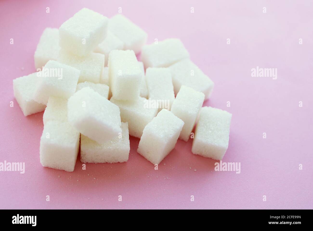 sugar cubes on light pink background Stock Photo - Alamy