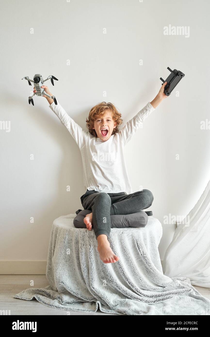 Child manipulating a drone and the remote control just given to him Stock Photo