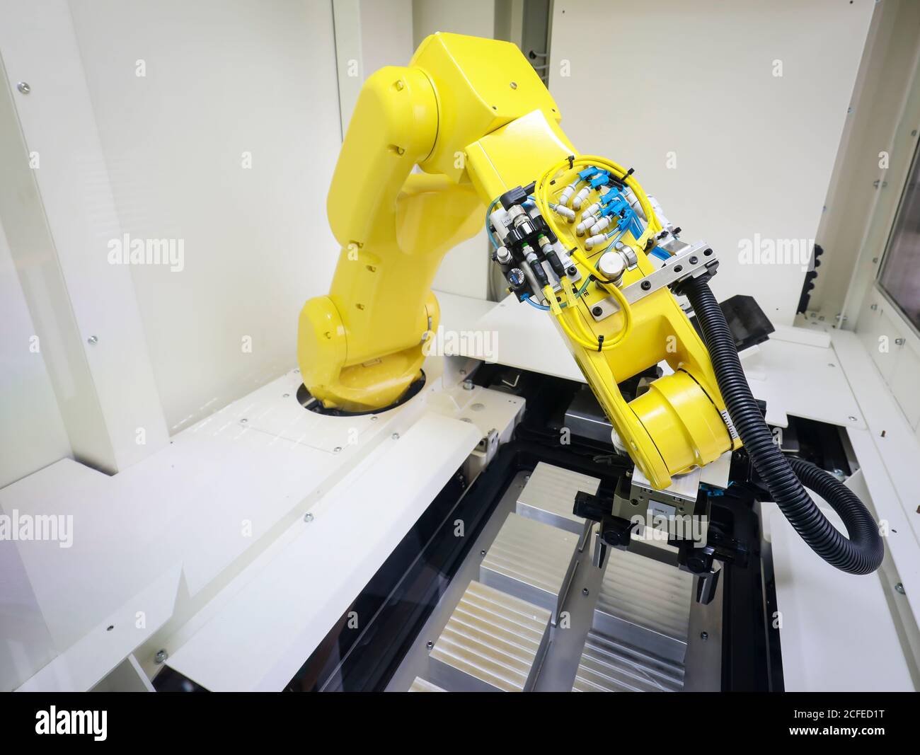 Bochum, North Rhine-Westphalia, Germany - robot arm equips a CNC milling machine with workpieces here at Stromboli Elektro und Feinwerktechnik on the Stock Photo