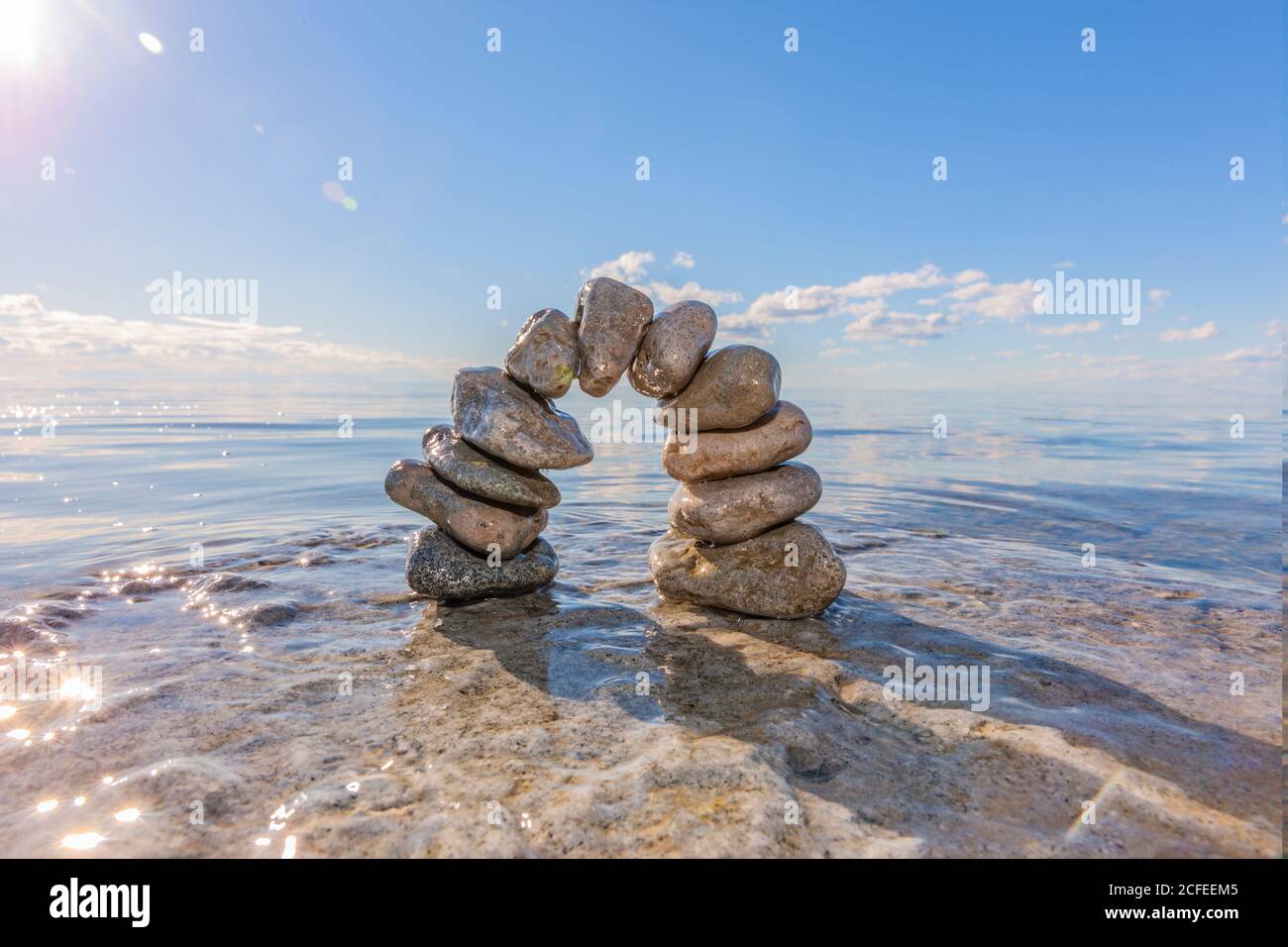 Stone arch made of pebbles in the water Stock Photo