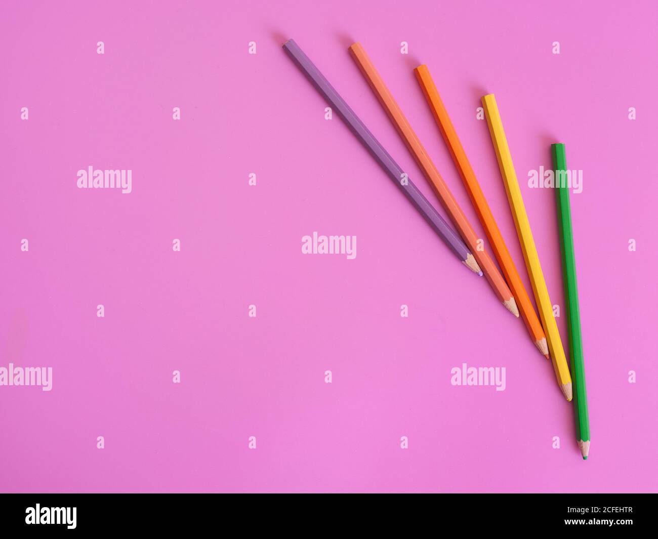 Color pencils on pink background copy space Stock Photo - Alamy