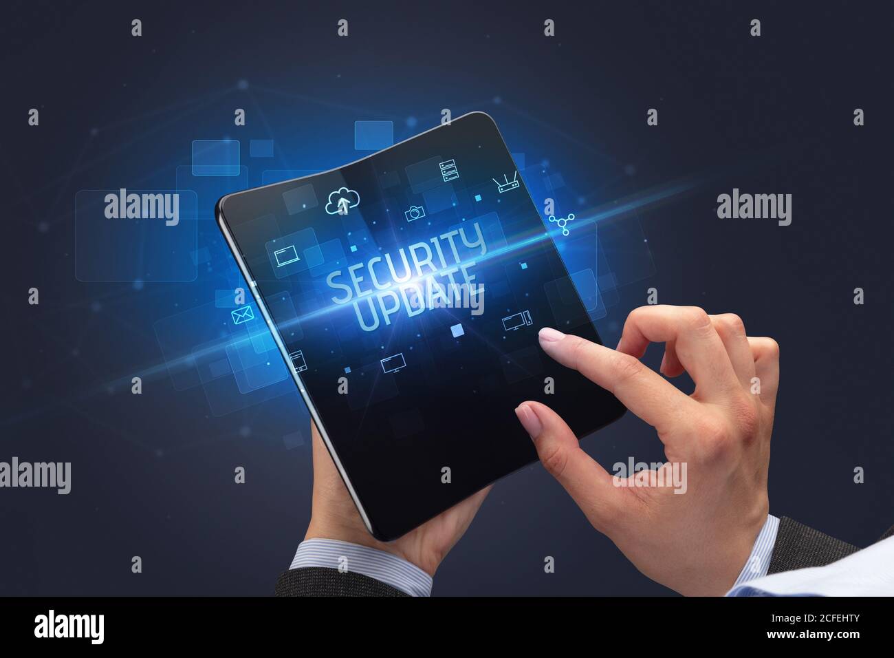 Businessman holding a foldable smartphone with SECURITY UPDATE inscription, cyber security concept Stock Photo