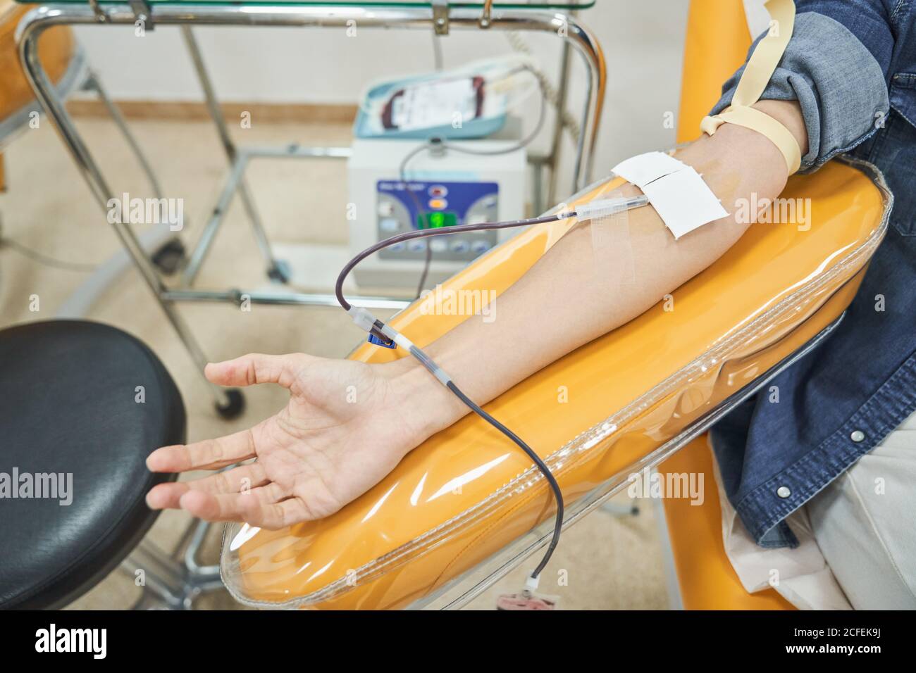 Crop anonymous female volunteer giving blood for save life in modern blood transfusion center Stock Photo