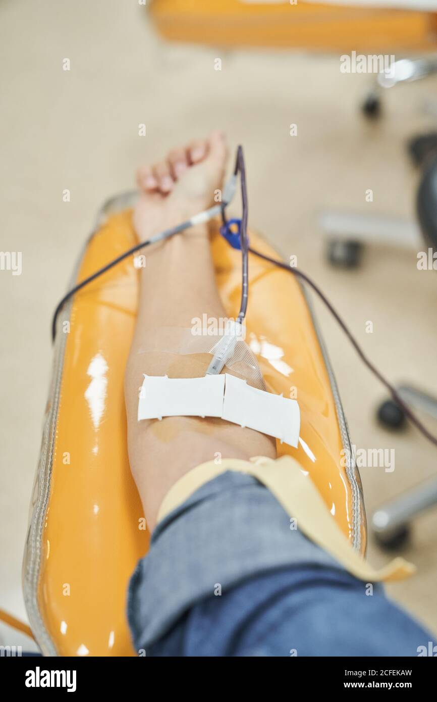 Crop anonymous female volunteer giving blood for save life in modern blood transfusion center Stock Photo