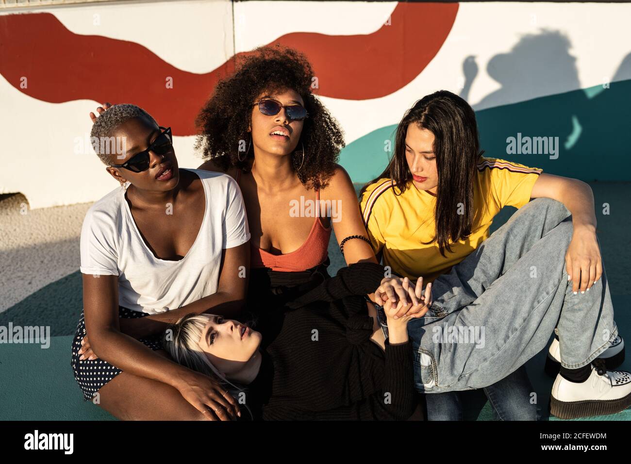 Cheerful young multiracial female friends enjoying free time in street Stock Photo