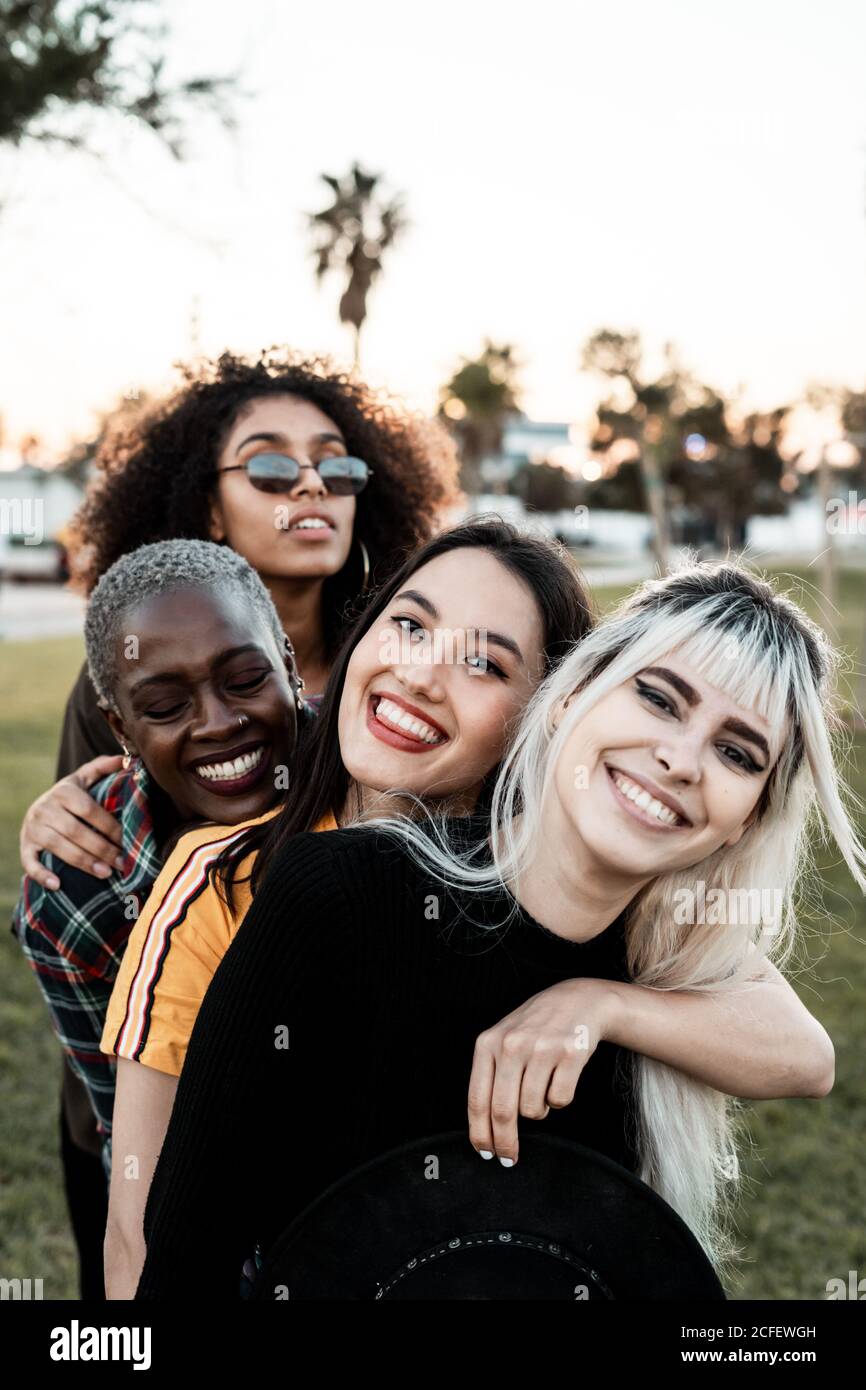 Multiethnic group of female hipsters cuddling with each one Stock Photo