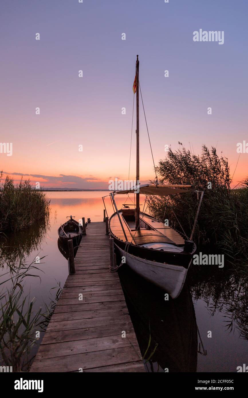 Moored boat by wooden pier Stock Photo - Alamy
