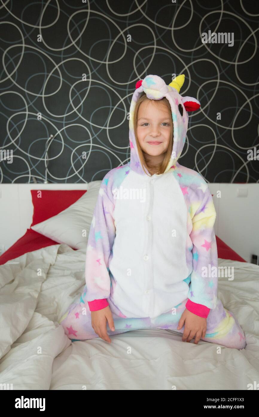 Cheerful girl in unicorn pajama having fun on bed Stock Photo - Alamy