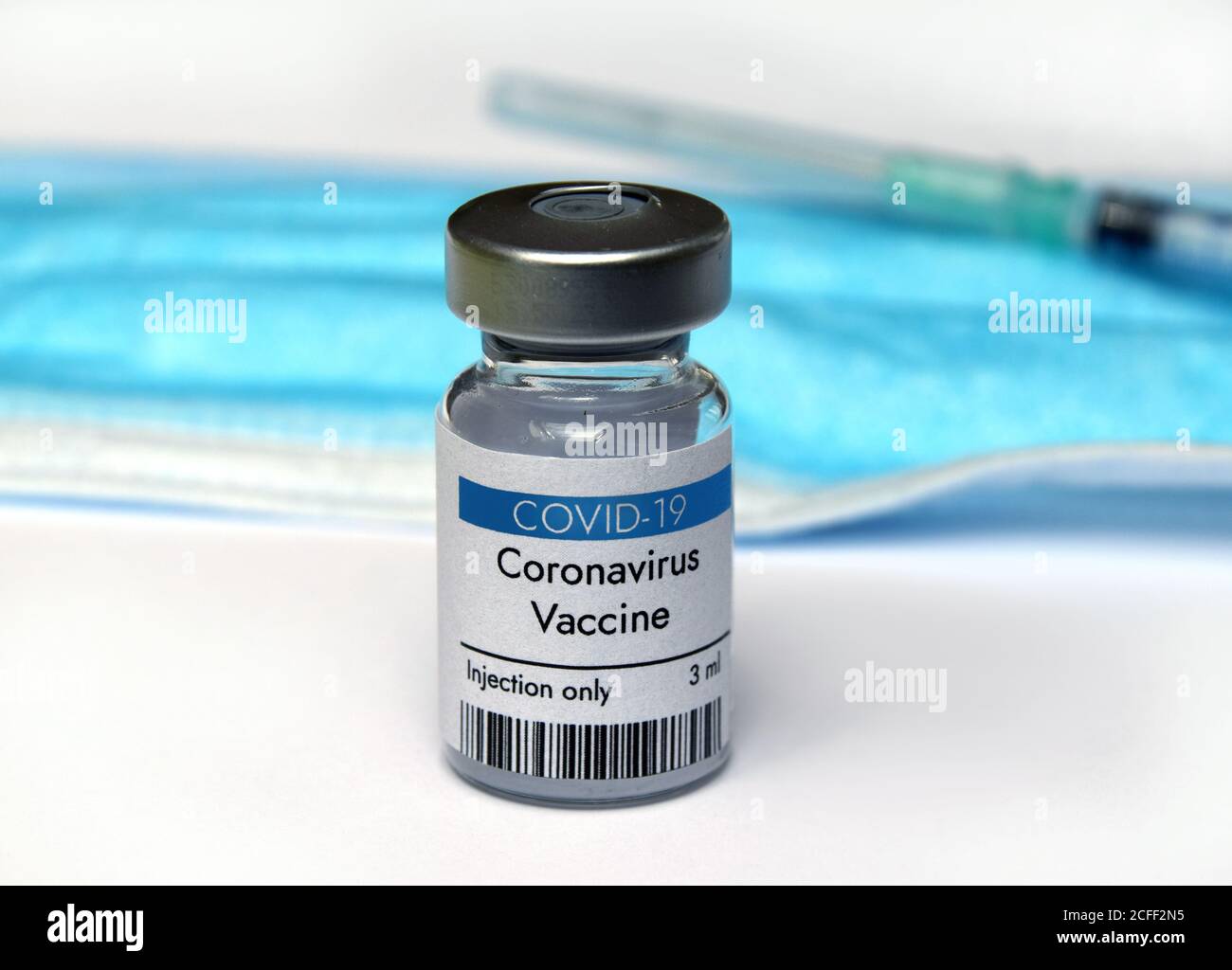 Coronavirus vaccine vial container in hand on white background. Close-up view. Coronavirus vaccine bottle. Stock Photo