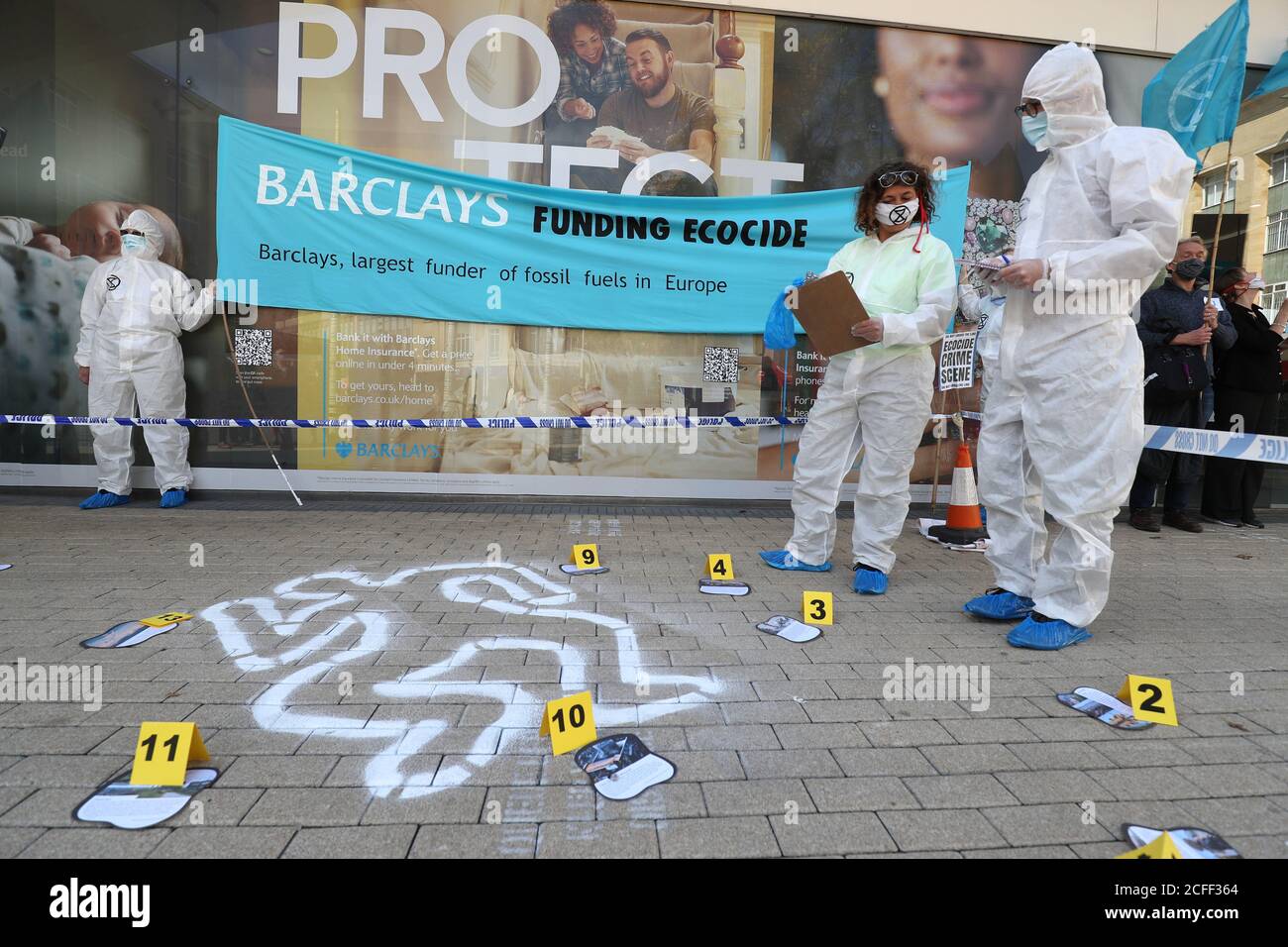 Protesters outside Barclays bank in Broadmead, Bristol, to protest against what they have termed the financing of climate devastation by the bank. Extinction Rebellion and Stop Ecocide created a mock crime scene outside the branch as part of the protest. Stock Photo