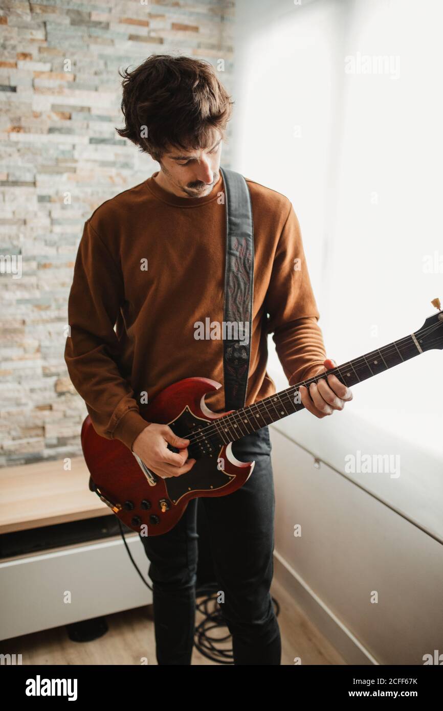 man playing guitar at home Stock Photo