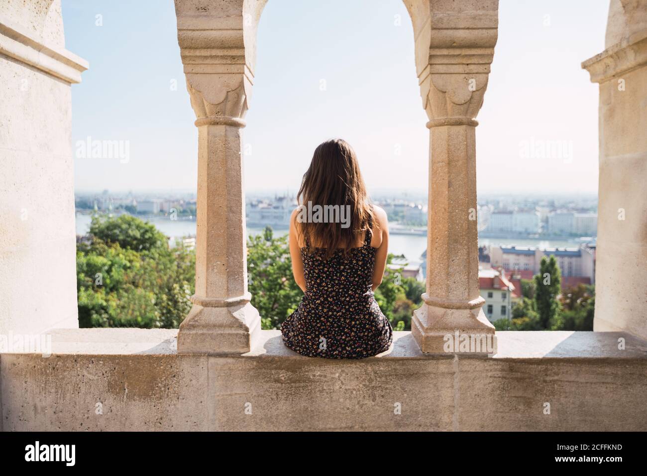 Back view woman sitting on wall hi-res stock photography and images - Alamy