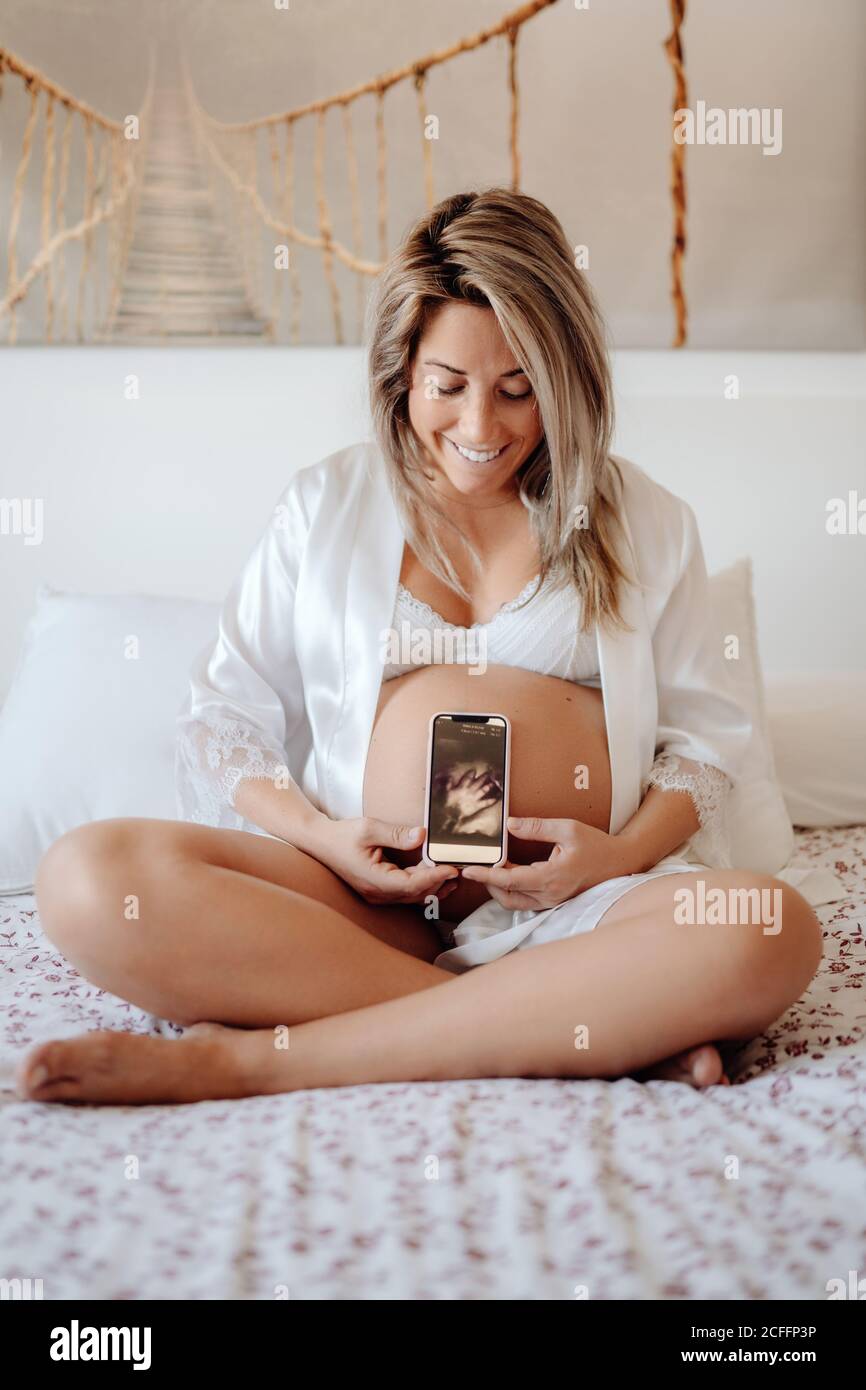 Pregnant Woman demonstrating picture of baby hans from ultrasound scan