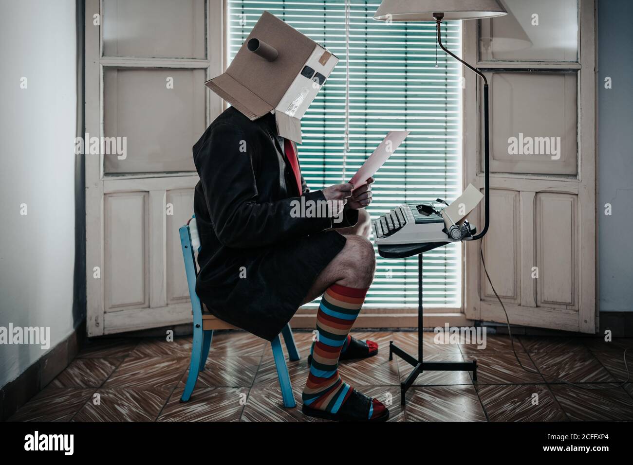 Side view of creative male writer sitting on small wooden chair at ...