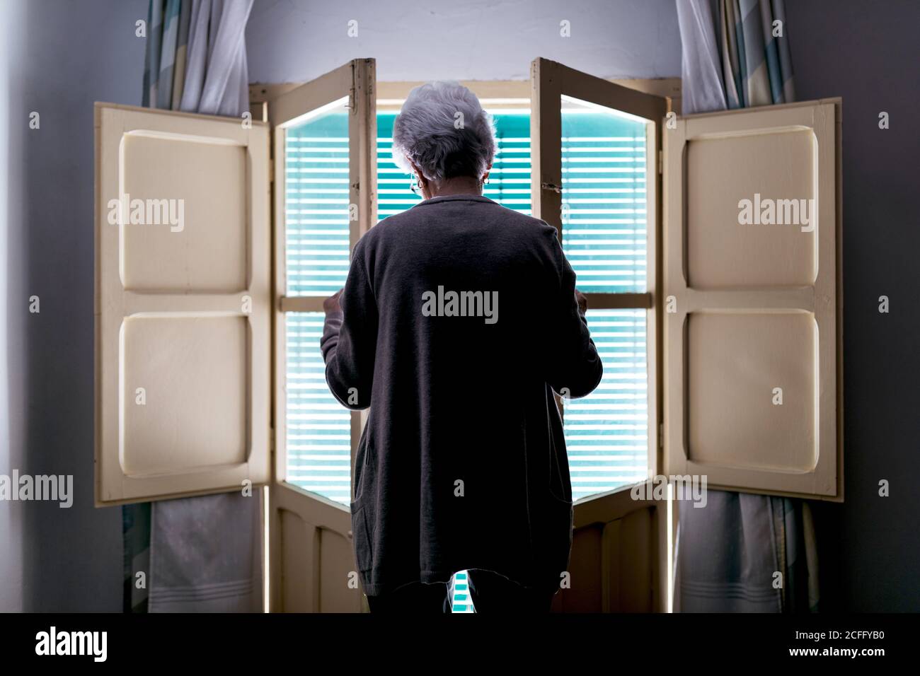 Woman in isolation opening window hi-res stock photography and images ...