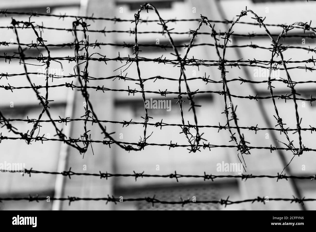 Black and white of spiky barbed wire above fence of local place of criminal confinement in Hong Kong Stock Photo