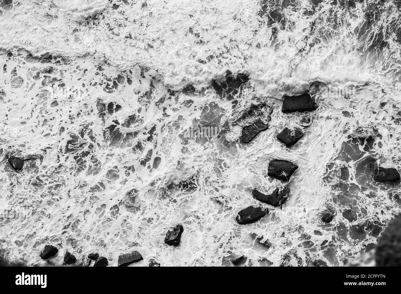 From above of dashing powerful waves of dark ocean with white foam in