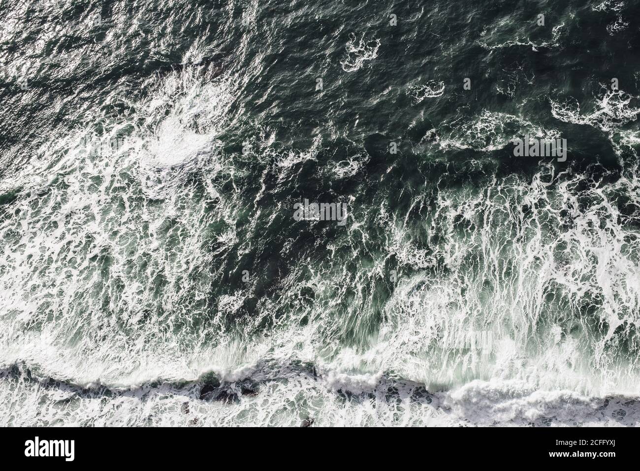 From above of dashing powerful waves of dark ocean with white foam in Ireland Stock Photo