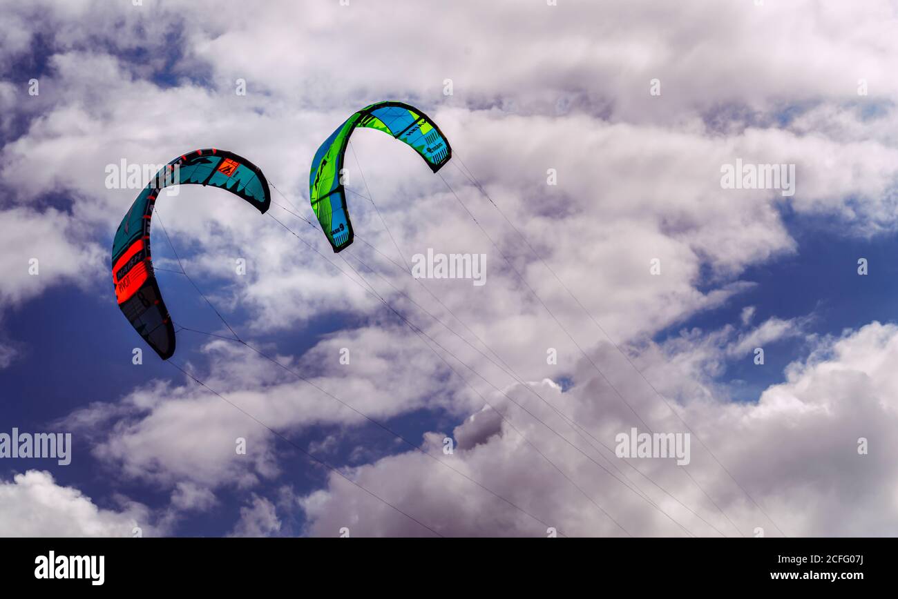 IJMUIDEN BEACH, THE NETHERLANDS AUGUST 23, 2020. Two Colorful board kites against a blue and cloudy sky Stock Photo