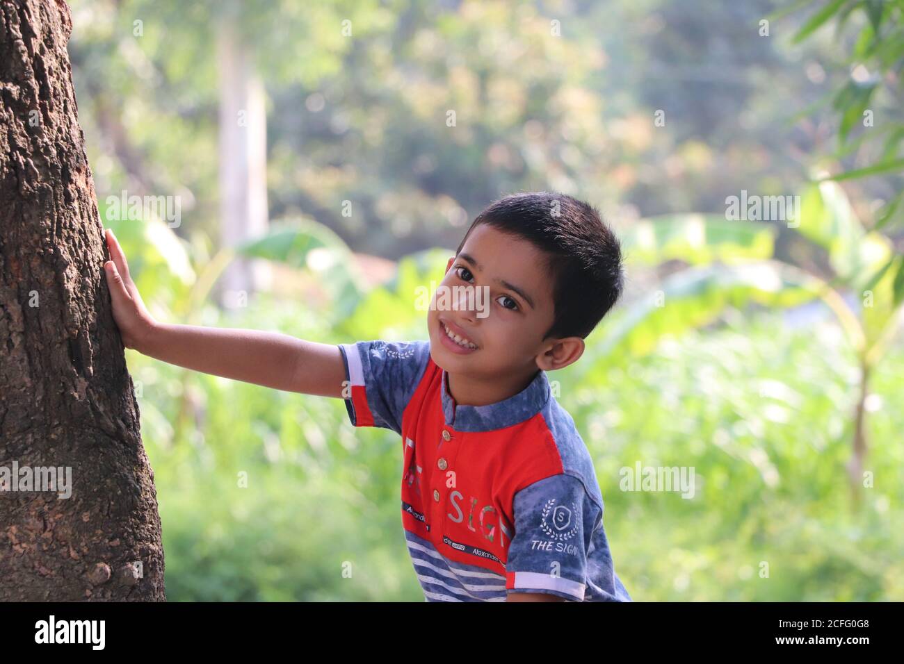 Cute little boy smiling, expressing happiness while posing for photo in the village Stock Photo