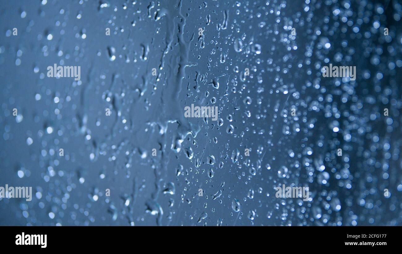 Glass surface full of water drops in rainy day on blue background Stock ...