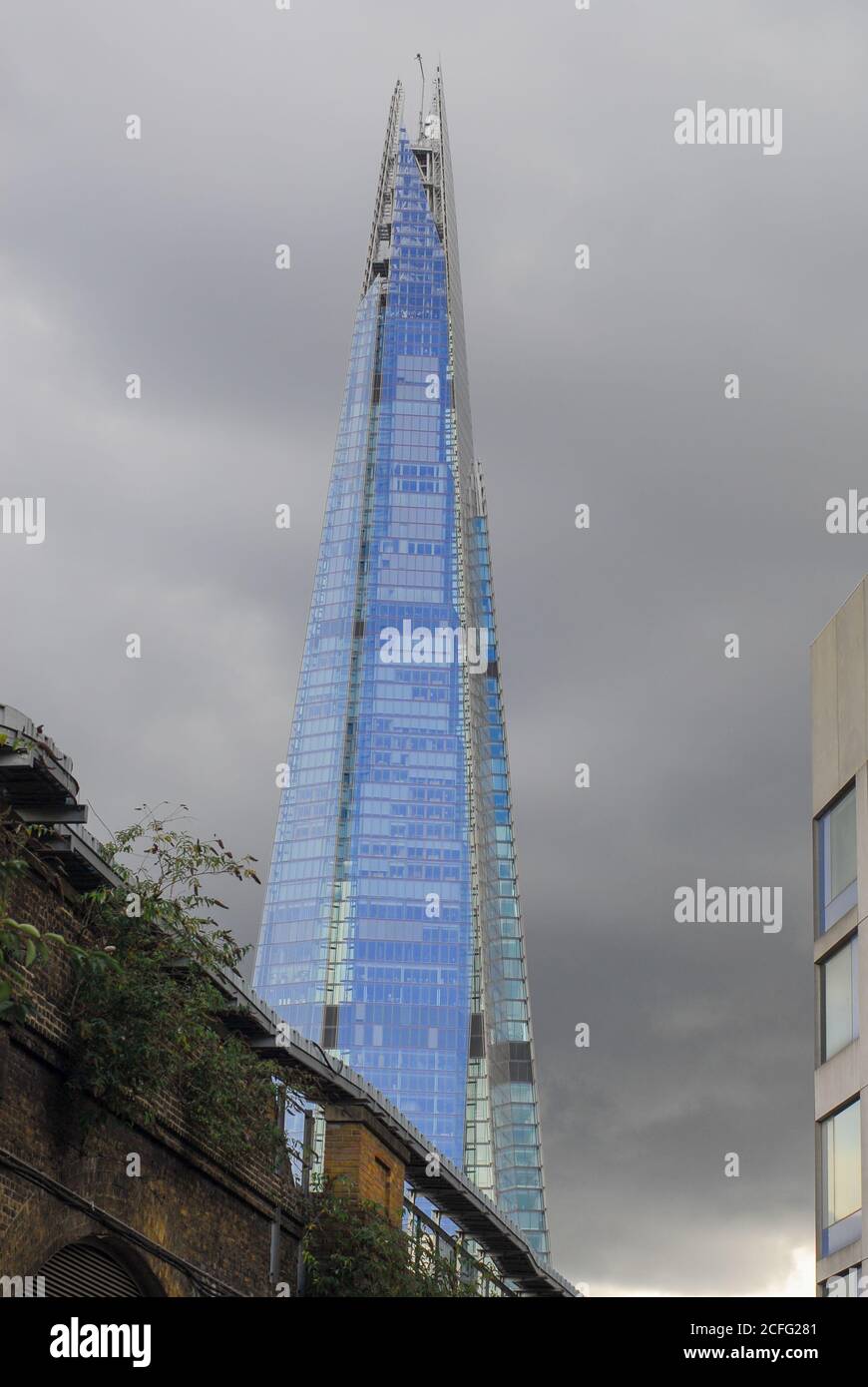 Dramatic moody view of The Shard. London. Threatening dark clouds highlight the blue tinted glass of the iconic building on the London skyline. Stock Photo