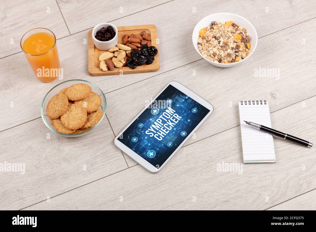 SYMPTOM CHECKER concept in tablet pc with healthy food around, top view