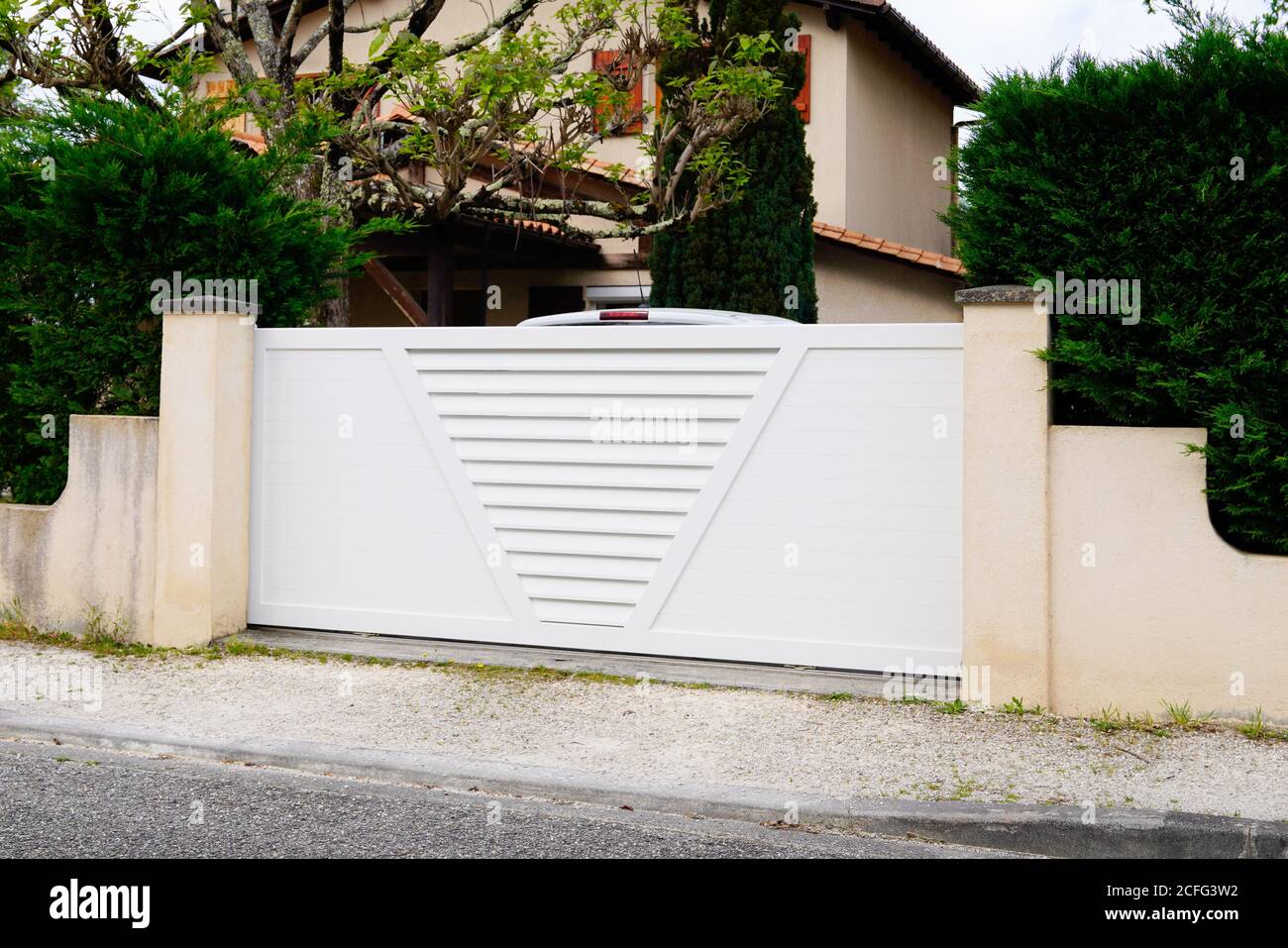 white suburban metal modern gate white fence on home suburb street access house garden Stock Photo